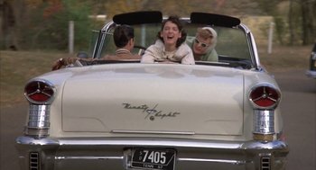 Movie still from “Great Balls of Fire!” (1989), directed by Jim McBride – A couple of people in the back seat of a car; Wide shot, Low angle