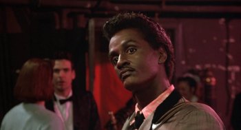 Movie still from “Great Balls of Fire!” (1989), directed by Jim McBride – A person wearing a suit and tie; Close Up shot, Low angle