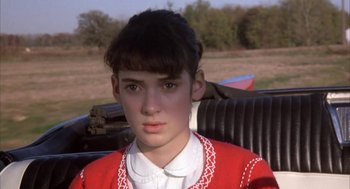 Movie still from “Great Balls of Fire!” (1989), directed by Jim McBride – A young woman sitting in the back of an antique car; Close Up shot, High angle