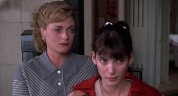 Movie still from “Great Balls of Fire!” (1989), directed by Jim McBride – Two women standing next to each other in front of a wall; Close Up shot, Low angle