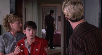 Movie still from “Great Balls of Fire!” (1989), directed by Jim McBride – A woman in a red jacket talking to a man in a striped shirt; Medium shot, Over the shoulder angle
