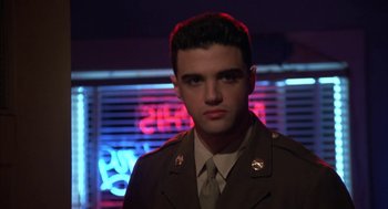 Movie still from “Great Balls of Fire!” (1989), directed by Jim McBride – A man in a military uniform standing in front of a neon sign; Close Up shot, Low angle