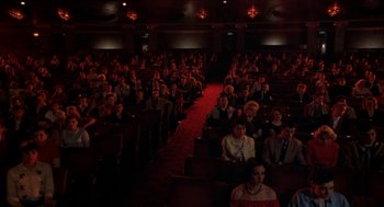 Movie still from “Great Balls of Fire!” (1989), directed by Jim McBride – A large group of people sitting in a theater; Extreme Wide shot, High angle