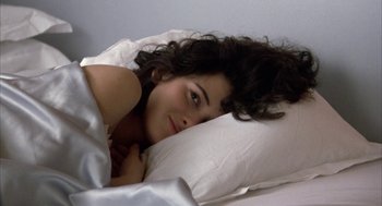 Movie still from “Great Balls of Fire!” (1989), directed by Jim McBride – A woman laying in a bed with a white pillow; Close Up shot, Overhead angle