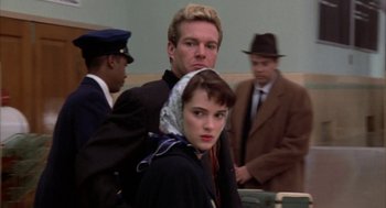 Movie still from “Great Balls of Fire!” (1989), directed by Jim McBride – A man and a woman standing next to each other in front of other men; Close Up shot, Low angle