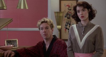 Movie still from “Great Balls of Fire!” (1989), directed by Jim McBride – A man and a woman sitting next to each other in a room; Medium shot, Low angle