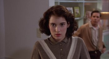 Movie still from “Great Balls of Fire!” (1989), directed by Jim McBride – A young woman in a brown and white sweater; Close Up shot, Over the shoulder angle
