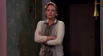 Movie still from “Great Balls of Fire!” (1989), directed by Jim McBride – A woman standing with her arms crossed; Medium shot, Low angle