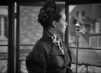 Movie still from “Green Dolphin Street” (1947), directed by Victor Saville – A black and white photo of a woman with a microphone; Medium shot, Over the shoulder angle