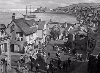 Movie still from “Green Dolphin Street” (1947), directed by Victor Saville – A black and white photo of a town with people walking on the street; Extreme Wide shot, High angle