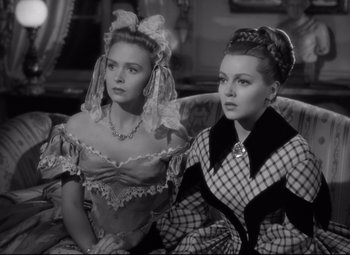 Movie still from “Green Dolphin Street” (1947), directed by Victor Saville – Two beautiful women sitting on a couch in a room; Medium shot, Over the shoulder angle