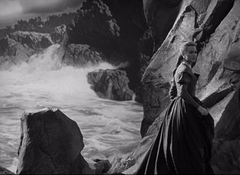 Movie still from “Green Dolphin Street” (1947), directed by Victor Saville – A black and white photo of a woman standing on a cliff; Wide shot, High angle