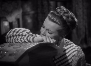 Movie still from “Green Dolphin Street” (1947), directed by Victor Saville – A black and white photo of a woman leaning on a box; Close Up shot, High angle