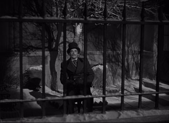 Movie still from “Green Dolphin Street” (1947), directed by Victor Saville – A black and white photo of a man standing in front of a fence; Wide shot, High angle