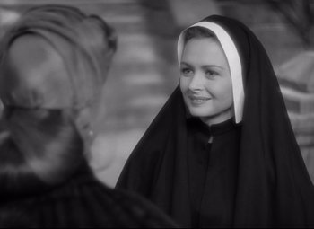 Movie still from “Green Dolphin Street” (1947), directed by Victor Saville – A woman in a nun's habit smiles for the camera; Close Up shot, Over the shoulder angle