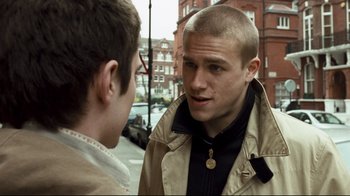 Movie still from “Green Street Hooligans” (2005), directed by Lexi Alexander – Two young men talking on the sidewalk of a city street; Close Up shot, Over the shoulder angle