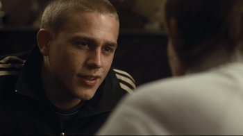Movie still from “Green Street Hooligans” (2005), directed by Lexi Alexander – A man sitting in front of another man in a room; Close Up shot, Over the shoulder angle