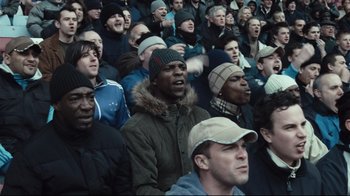 Movie still from “Green Street Hooligans” (2005), directed by Lexi Alexander – A group of people that are sitting in a stadium; Medium shot, High angle