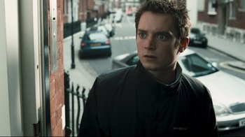 Movie still from “Green Street Hooligans” (2005), directed by Lexi Alexander – A man standing on the side of a building; Close Up shot, Over the shoulder angle