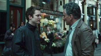 Movie still from “Green Street Hooligans” (2005), directed by Lexi Alexander – Two men standing next to each other on the sidewalk; Medium shot, Over the shoulder angle