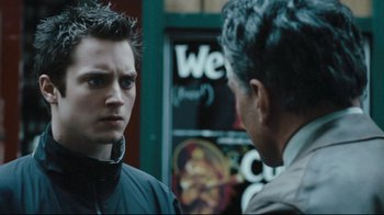 Movie still from “Green Street Hooligans” (2005), directed by Lexi Alexander – A man standing next to another man on a street; Close Up shot, Over the shoulder angle