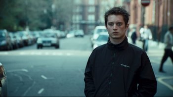 Movie still from “Green Street Hooligans” (2005), directed by Lexi Alexander – A man standing on the side of the street; Close Up shot, Over the shoulder angle