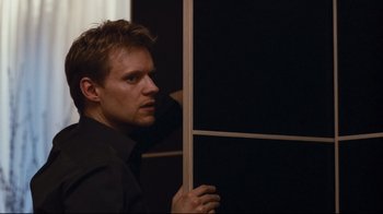 Movie still from “Green Street Hooligans” (2005), directed by Lexi Alexander – A man holding a wooden stick in front of a wall; Close Up shot, Over the shoulder angle