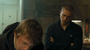 Movie still from “Green Street Hooligans” (2005), directed by Lexi Alexander – A man with a shaved head is standing next to another man with a shaved head; Medium shot, Over the shoulder angle