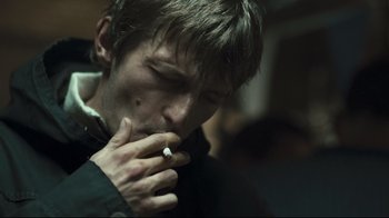 Movie still from “Green Street Hooligans” (2005), directed by Lexi Alexander – A person smoking a cigarette; Close Up shot, Over the shoulder angle