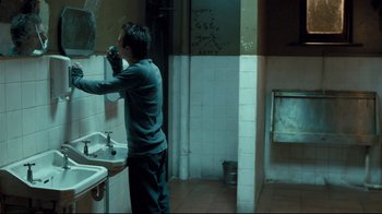 Movie still from “Green Street Hooligans” (2005), directed by Lexi Alexander – A man is brushing his teeth in a bathroom; Medium shot, Over the shoulder angle