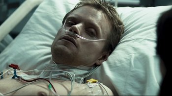 Movie still from “Green Street Hooligans” (2005), directed by Lexi Alexander – A man laying in a hospital bed with a tube in his mouth; Close Up shot, Overhead angle
