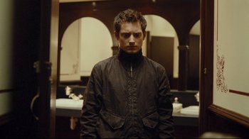 Movie still from “Green Street Hooligans” (2005), directed by Lexi Alexander – A man in a black jacket standing in front of a mirror; Medium shot, Over the shoulder angle