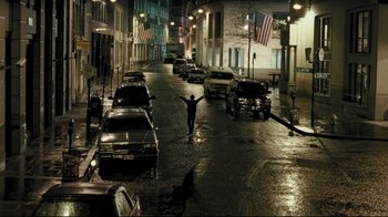 Movie still from “Green Street Hooligans” (2005), directed by Lexi Alexander – A man standing in the middle of a street at night; Extreme Wide shot, High angle