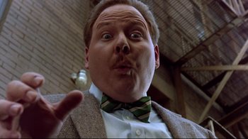 Movie still from “Gremlins 2: The New Batch” (1990), directed by Joe Dante – A person wearing a suit and tie; Close Up shot, Low angle