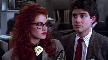 Movie still from “Gremlins 2: The New Batch” (1990), directed by Joe Dante – A man and a woman are standing next to each other; Close Up shot, Over the shoulder angle