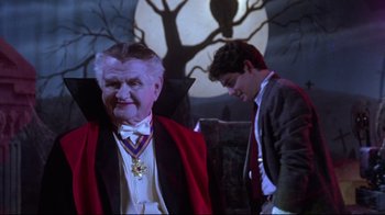 Movie still from “Gremlins 2: The New Batch” (1990), directed by Joe Dante – Two men dressed up as vampires in front of a full moon; Medium shot, Low angle