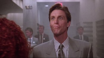 Movie still from “Gremlins 2: The New Batch” (1990), directed by Joe Dante – A man in a suit and tie looking up at the ceiling; Close Up shot, Low angle