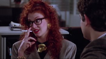 Movie still from “Gremlins 2: The New Batch” (1990), directed by Joe Dante – A woman with red curly hair talking on a cell phone; Close Up shot, Over the shoulder angle