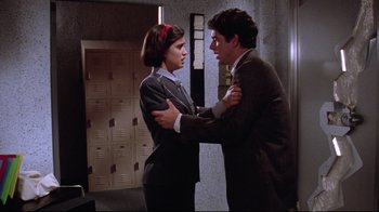 Movie still from “Gremlins 2: The New Batch” (1990), directed by Joe Dante – A man and a woman in a room with lockers in front of them; Medium shot, Over the shoulder angle