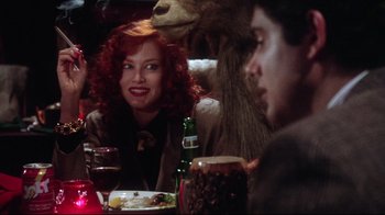Movie still from “Gremlins 2: The New Batch” (1990), directed by Joe Dante – A group of people sitting at a dinner table; Medium shot, Over the shoulder angle