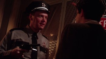 Movie still from “Gremlins 2: The New Batch” (1990), directed by Joe Dante – A police officer talking to a man in a police uniform; Close Up shot, Over the shoulder angle