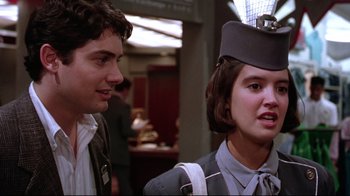 Movie still from “Gremlins 2: The New Batch” (1990), directed by Joe Dante – A man standing next to a woman wearing a hat; Close Up shot, Low angle