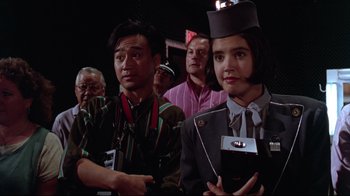 Movie still from “Gremlins 2: The New Batch” (1990), directed by Joe Dante – A group of people standing in front of a camera; Medium shot, Low angle