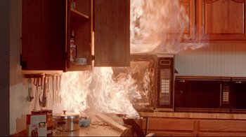 Movie still from “Gremlins 2: The New Batch” (1990), directed by Joe Dante – A kitchen with a fire coming out of the oven; Medium shot, High angle