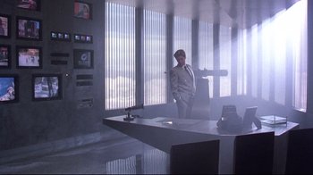 Movie still from “Gremlins 2: The New Batch” (1990), directed by Joe Dante – A man standing in front of a window in a room; Wide shot, Low angle