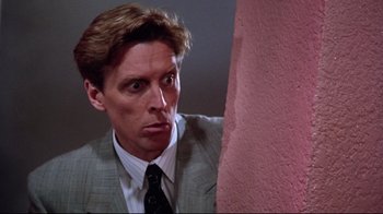 Movie still from “Gremlins 2: The New Batch” (1990), directed by Joe Dante – A person wearing a suit and tie; Close Up shot, Low angle