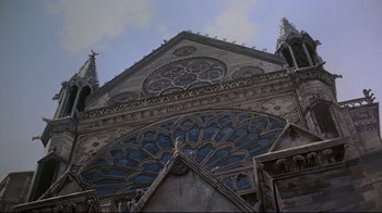 Movie still from “Gremlins 2: The New Batch” (1990), directed by Joe Dante – A large cathedral with a large stained - glass window; Extreme Wide shot, Low angle