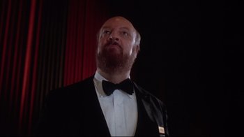 Movie still from “Gremlins 2: The New Batch” (1990), directed by Joe Dante – A man wearing a tuxedo and a bow tie; Close Up shot, Low angle