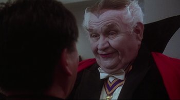 Movie still from “Gremlins 2: The New Batch” (1990), directed by Joe Dante – An old man with a white beard is talking to a young man; Close Up shot, Over the shoulder angle