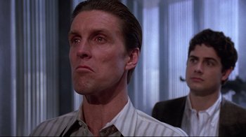 Movie still from “Gremlins 2: The New Batch” (1990), directed by Joe Dante – A person wearing a suit and tie; Close Up shot, Low angle